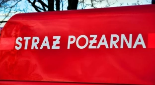 Straż pożarna jedzie na akcję i czeka na przejazd na czerwonym świetle